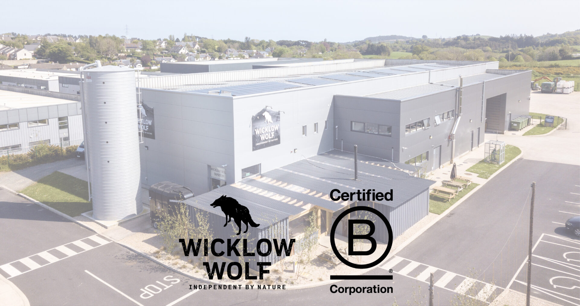 Wicklow Wolf B Corp Image Header - Photo of the brewery from outside featuring the Wicklow Wolf Logo and The B Corp Logo